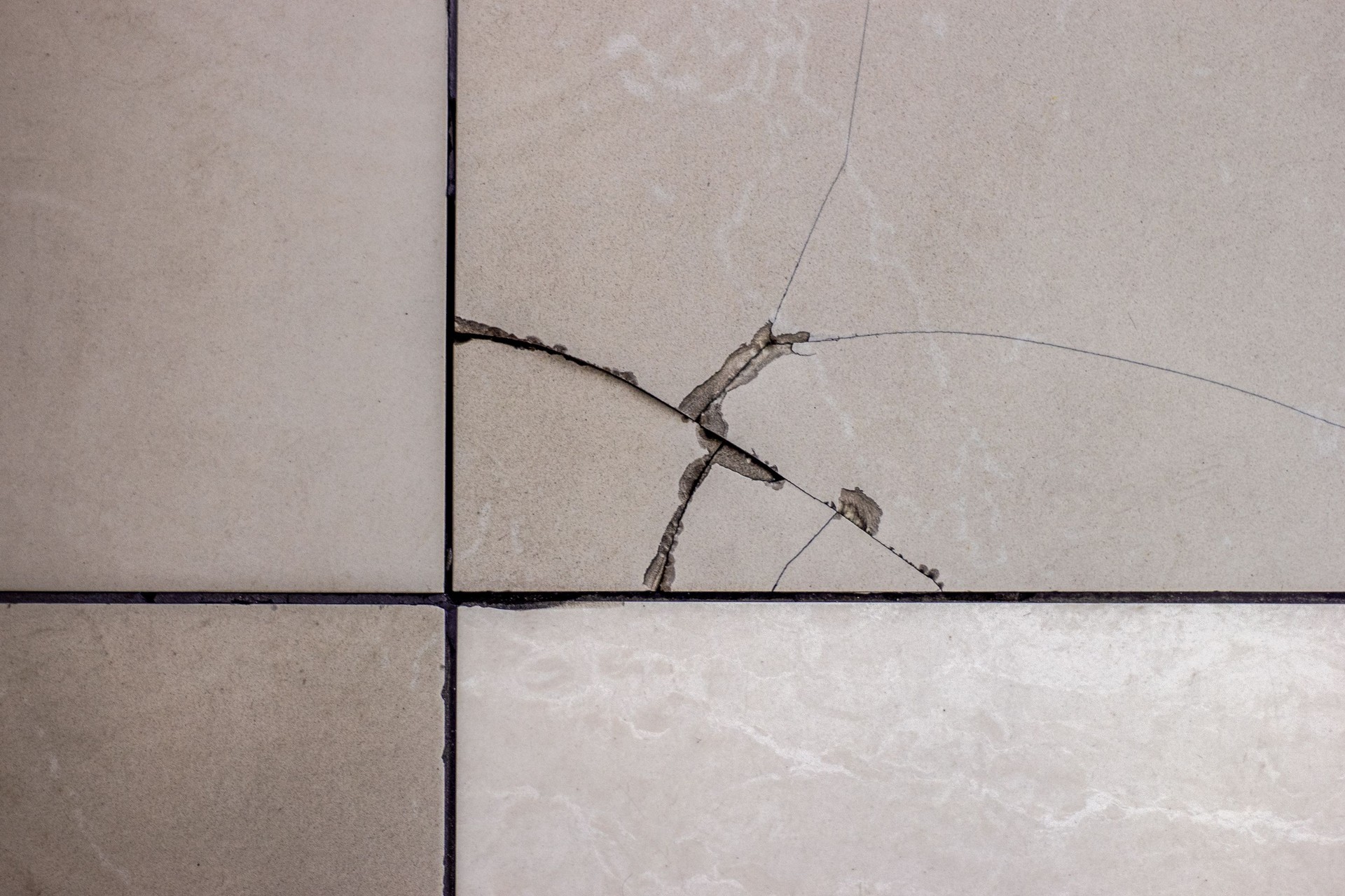 Cracked tile. Broken tile on the floor.