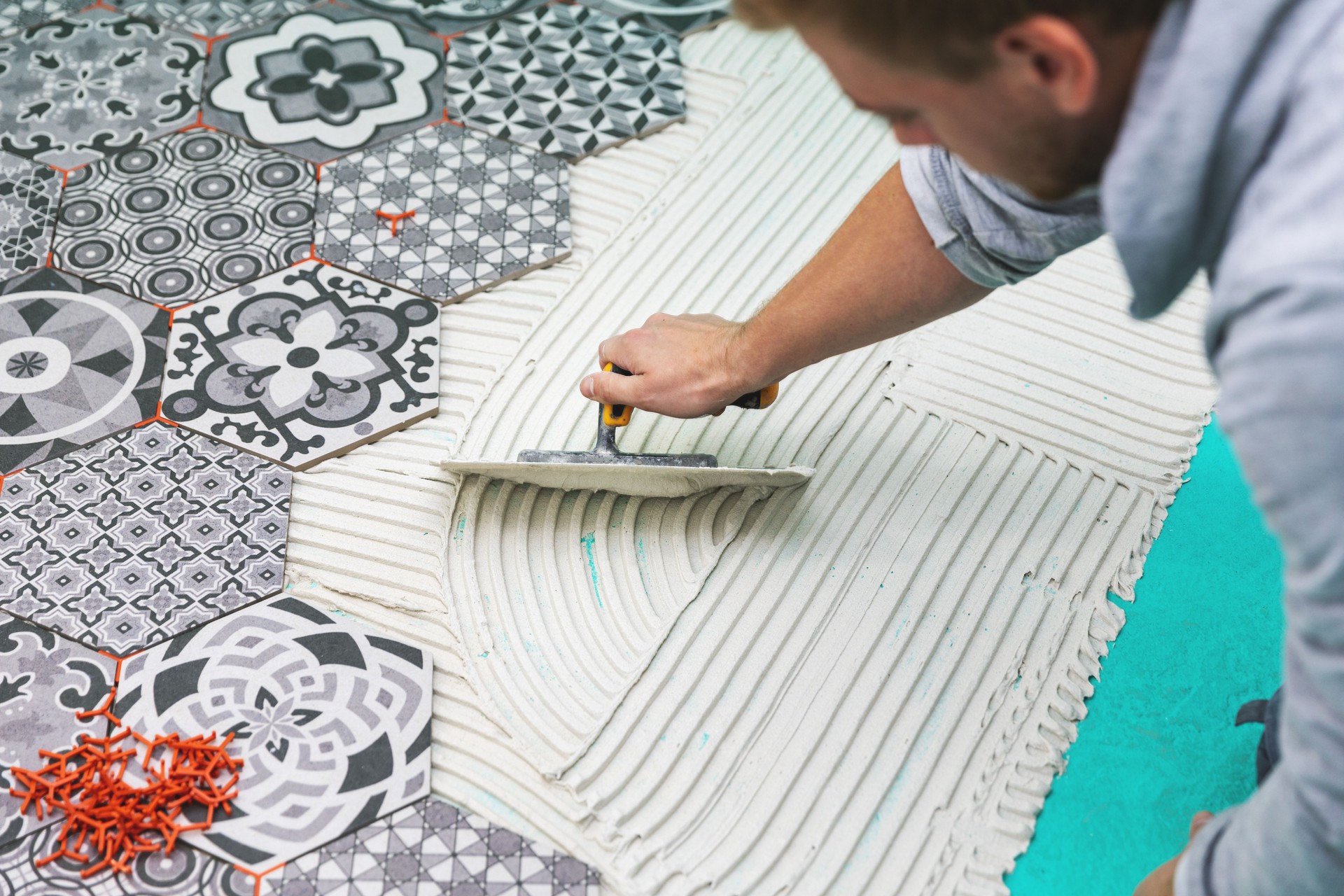 worker applying tile adhesive on the floor